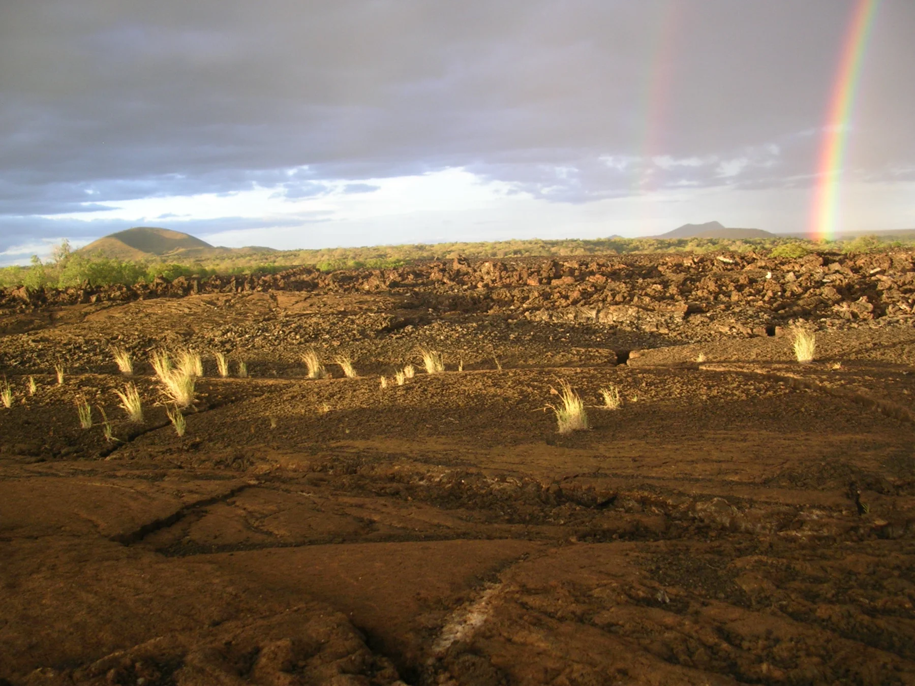 A rainbow above hills and lava at Shetani